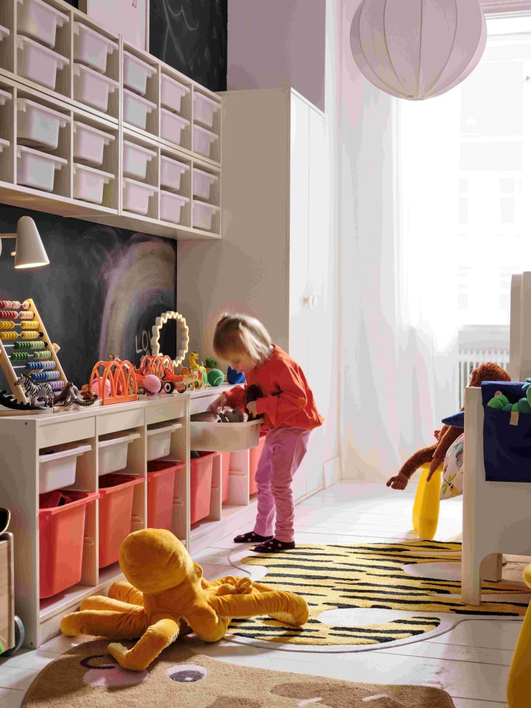 Ein Mädchen kramt in einem Regal von Ikea im Kinderzimmer